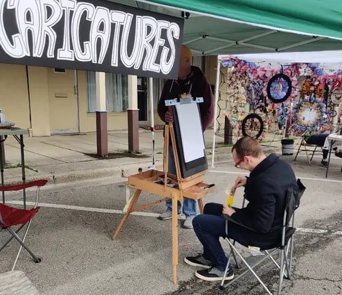 Photo of Ben White drawing at his Caricature Booth at a local fair.